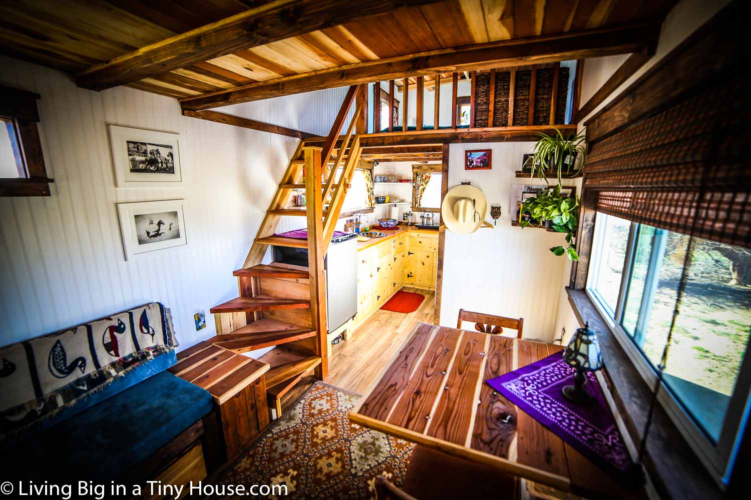 Rustic tiny house has a spacious interior and a balcony up top